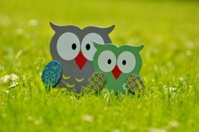 wood owl figurines in the grass