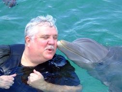 Dolphin Kissing happy old manâs cheek