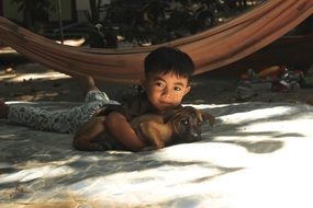 baby with a puppy in thailand