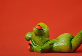 Frog resting on a red background