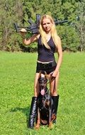 woman with rifle and doberman