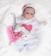baby doll and teddy hare on a white pillow