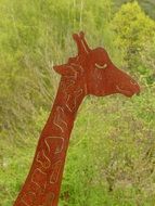 metal figure of a giraffe on a background of trees