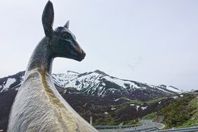 deer sculpture on the background of picturesque mountains
