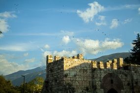 castle in the mountains under a cloudy sky