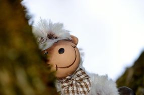 plush toy in the form of a sheep on a tree