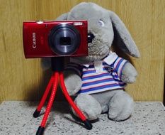 Canon camera on a tripod and a soft toy