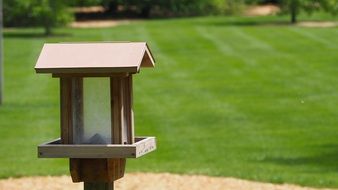 wooden feeder on a green lawn