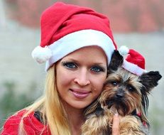 woman and yorkshire terrier with santa claus hat
