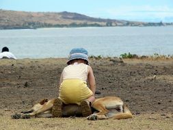 Child playing with Dog on beach