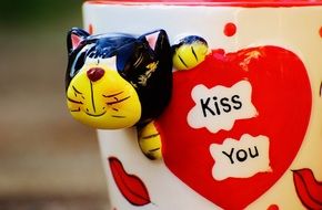 coffee cup with funny cat close-up on blurred background