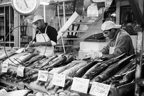sellers at market stall with fish