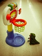 toy basketball ring and toy dinosaur