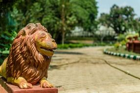 Beautiful lion statue in the park with colorful plants
