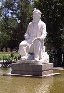 White statue of a Persian poet near the plants in iran