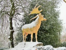 wooden statue of a deer in the snow