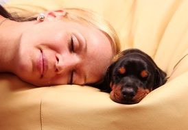 Doberman puppy and a girl on the couch