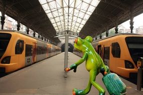 ceramic figure of a frog with a suitcase at the station