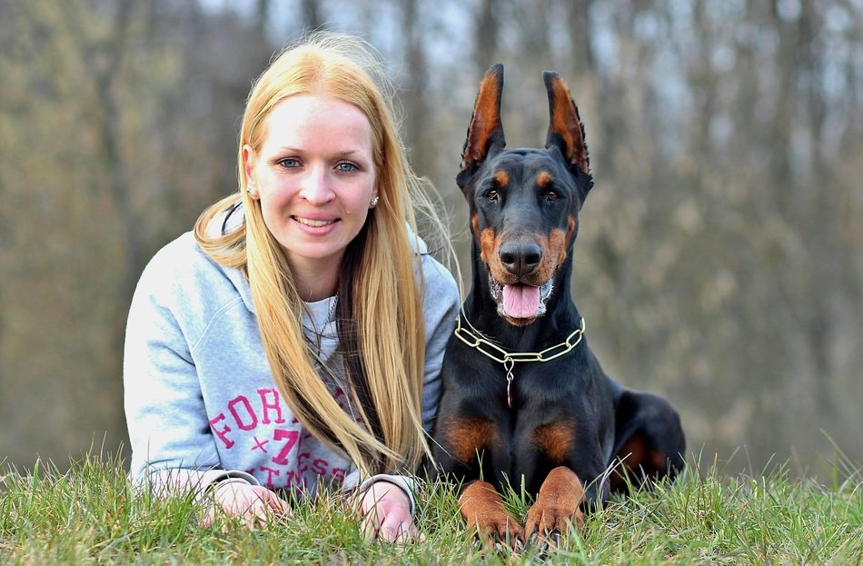 blonde and her dog breed ' Doberman'