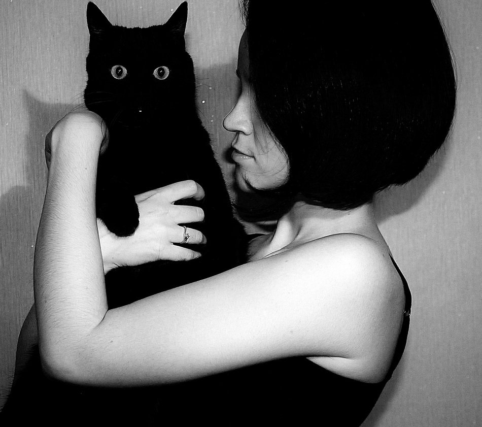 black cat in the hands of a girl in black and white background