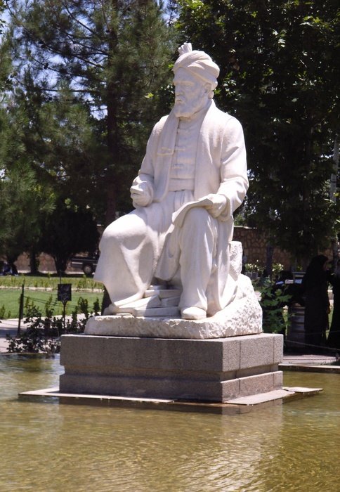 White statue of a Persian poet near the plants in iran