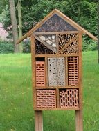 house for insects in a green meadow