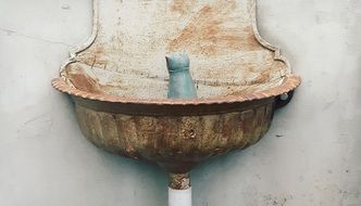 sculpture of a bird on a metal washbasin with a tap