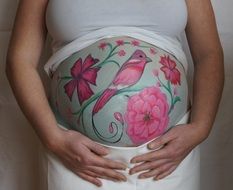 bird and flowers, drawing on a pregnant belly