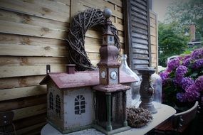 vintage Candle Holder and Bird House at wooden wall outdoor
