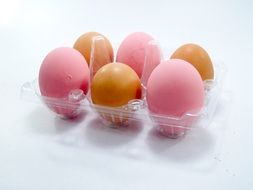 yellow and pink eggs in a box