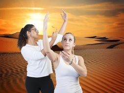 two dancing girls on the sand dunes background