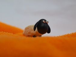 Toy Sheep on orange tissue