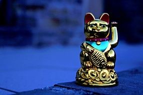 asian golden maneki neko at blue background