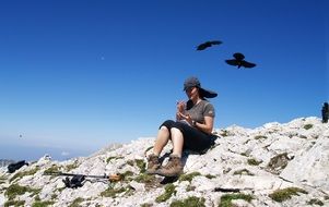 girl on a cliff on a background of flying birds