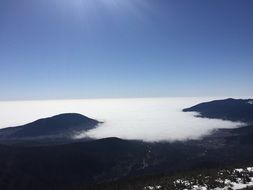 white clouds over mountain peaks