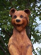 wooden sculpture of a bear on a background of green wood