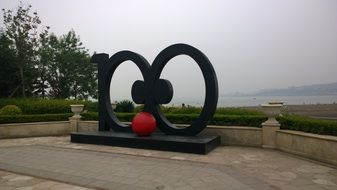 modern art object in park in front of sea, china, qingdao