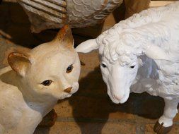 decorative stone figures of a sheep and a cat