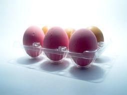 pink and yellow eggs in a plastic tray