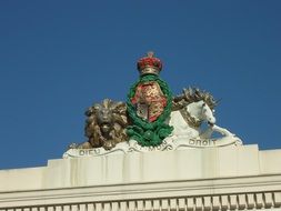 royal emblem on the facade of the white building