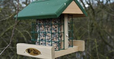 wooden aviary with a green roof for birds