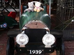 two soft toys on a retro car