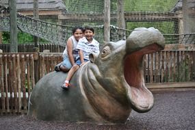 children on a hypopotamus in the park