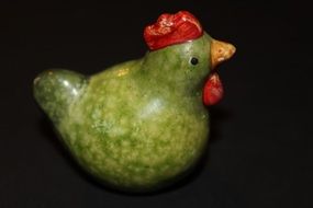 green ceramic chicken on black background