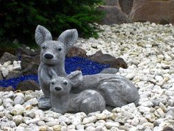 two stone figures of deer in the garden
