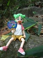 Colorful Doll Anime on the stone among the plants