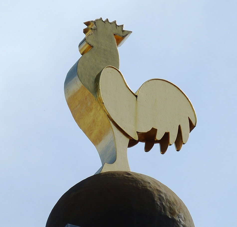 wooden rooster on the roof of the house