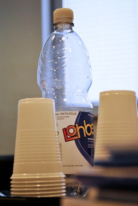 a bottle of water next to the glasses on the table