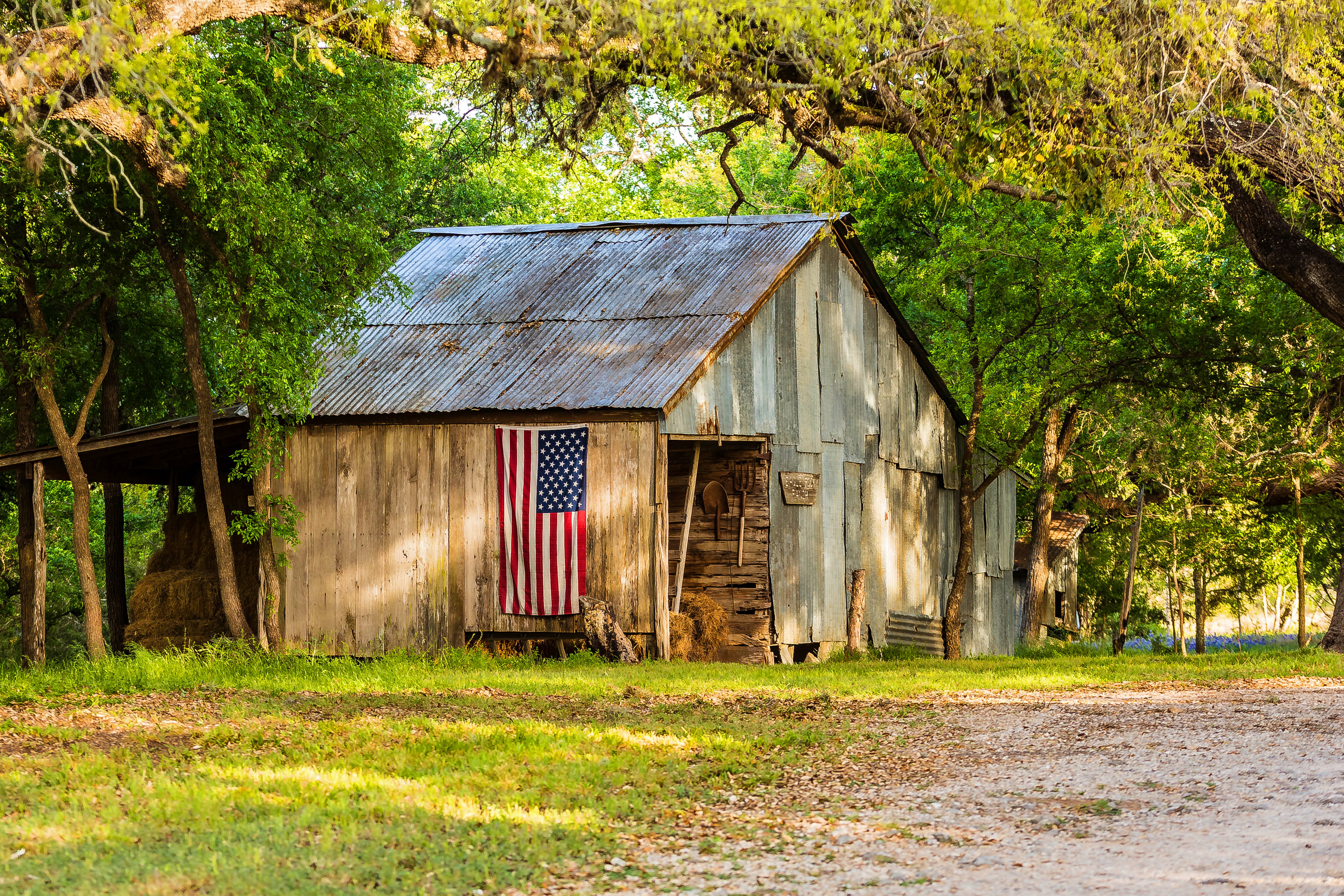 Old wooden Barn  with usa flag on wall in Country Landscape 