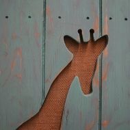 carved figure of a giraffe on a wooden wall